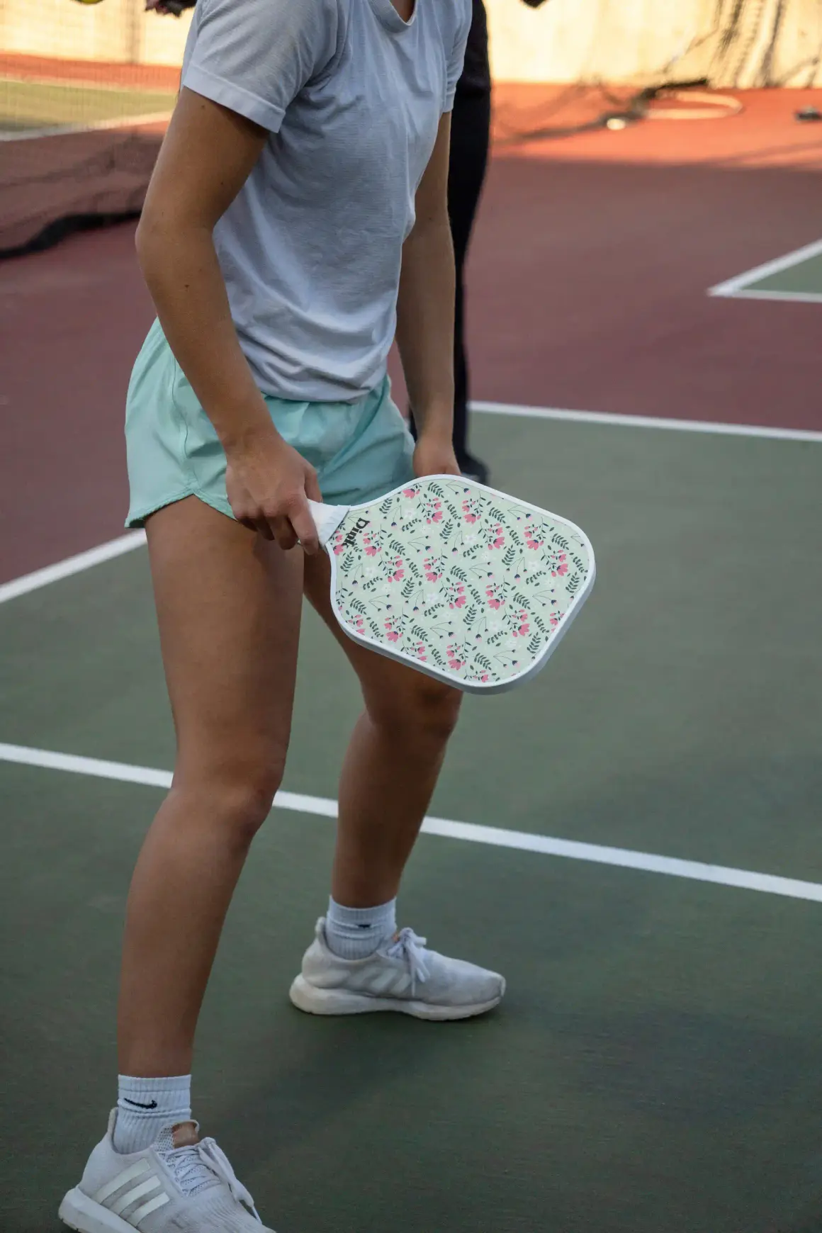 Pickleball player holding a Dink custom pickleball paddle