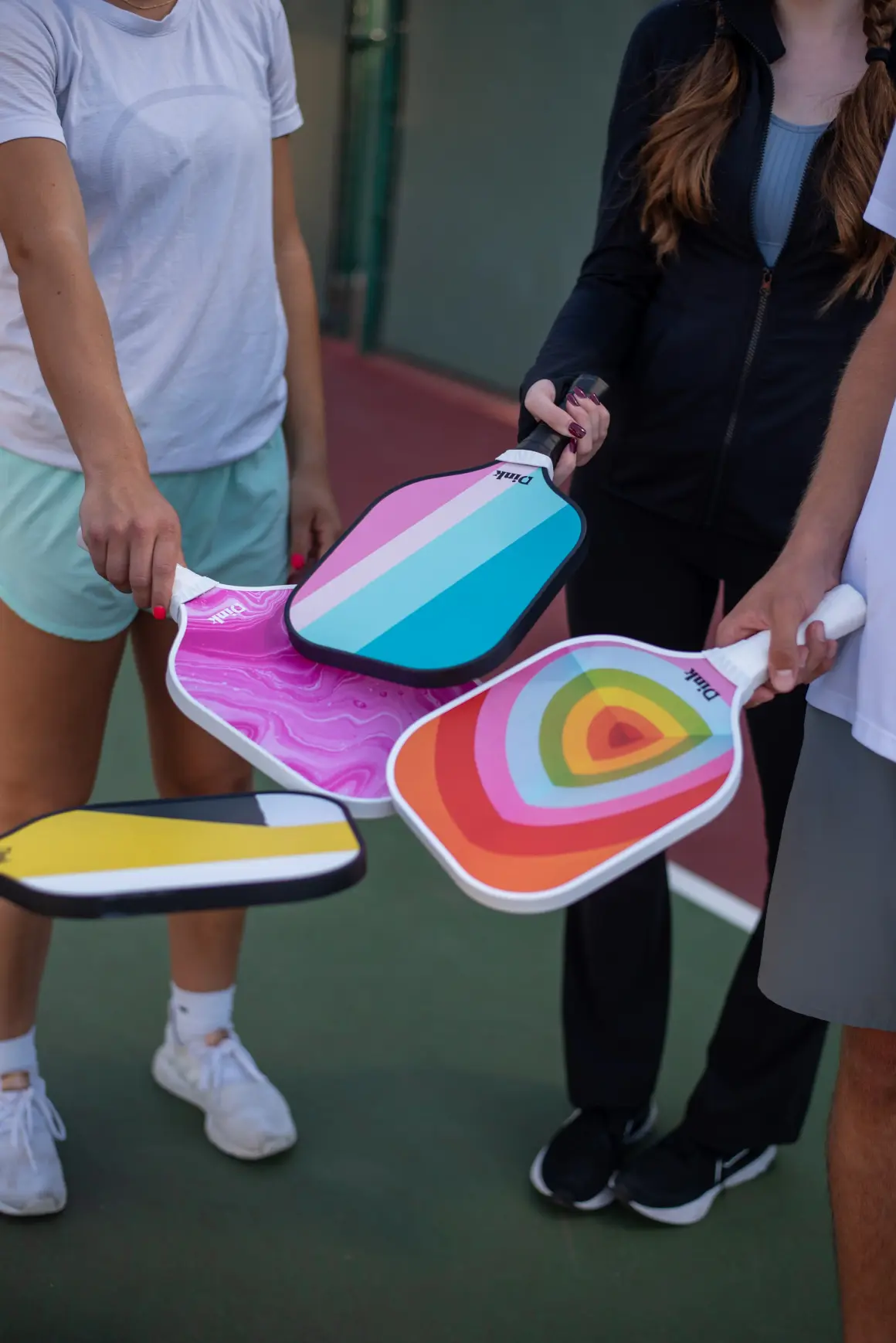 Pickleball player holding a Dink custom pickleball paddle